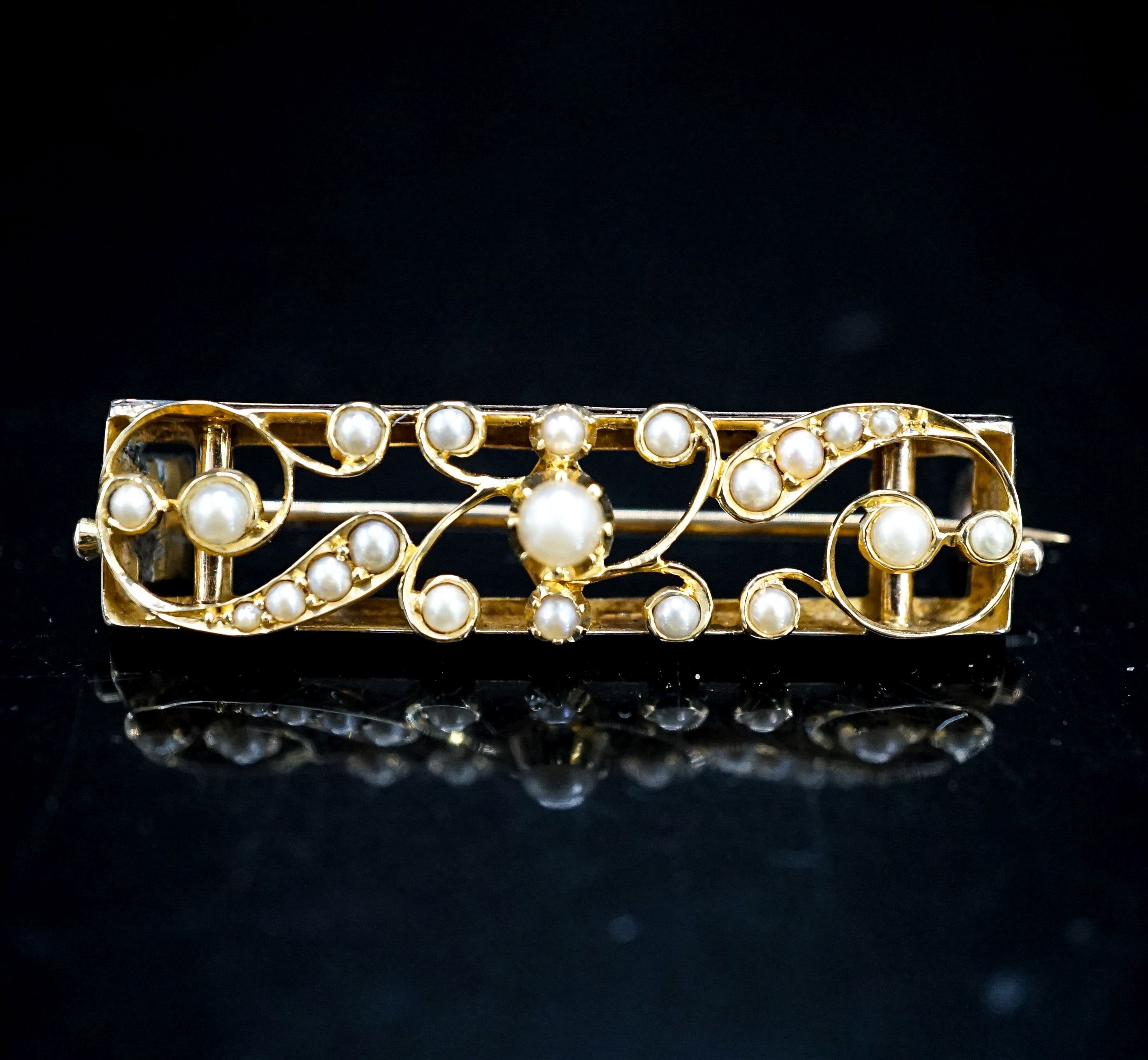 An early 20th century yellow metal and seed pearl set rectangular bar brooch, 38mm